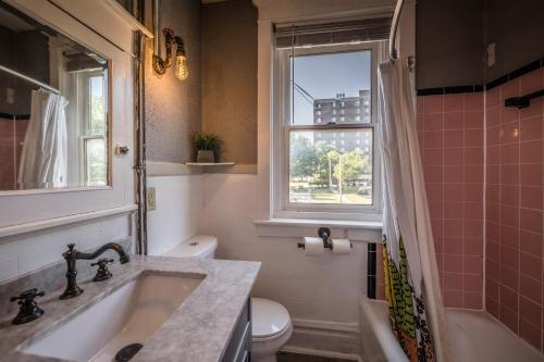 a bathroom with a sink and a toilet and a window at BurgBnB Riverfront in Harrisburg