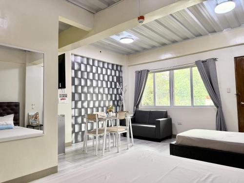 a bedroom with a bed and a table and a couch at MF Suites in Manolo Fortich
