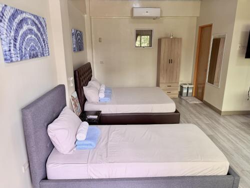 a room with two beds and a couch at MF Suites in Manolo Fortich