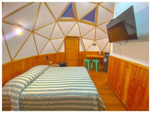 a room with a bed and a tv in a tent at Domos Frutillar in Frutillar