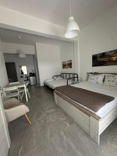 a bedroom with two beds and a table and a chair at AsproLux Seaside Studios in Asprovalta