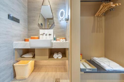 a bathroom with a sink and a mirror at Atour Hotel Kunming Hi-tech Wuyue Plaza in Kunming