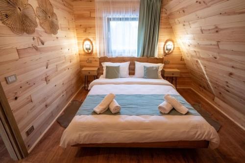 a bedroom with a large bed in a wooden room at Devi retreat in Arpaşu de Sus