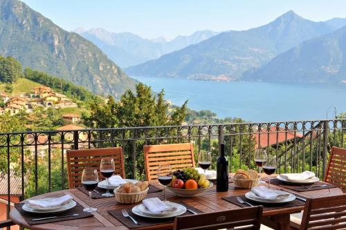 a wooden table with a bowl of fruit and wine glasses at Clubhouse in Menaggio