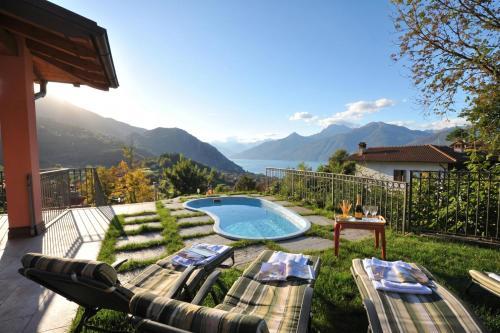 a backyard with a pool and a view of the mountains at Clubhouse in Menaggio