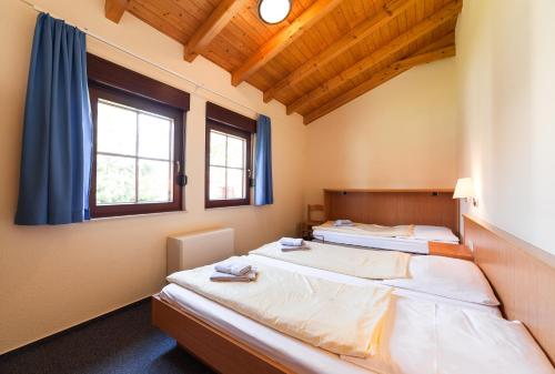 two beds in a room with two windows at Trixi Ferienpark Zittauer Gebirge in Großschönau