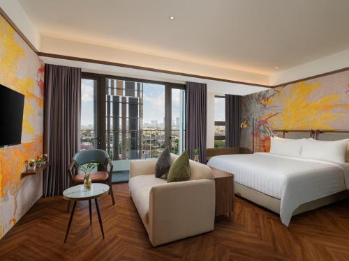 a hotel room with a bed and a couch at Elais by ARTOTEL in Medan