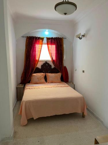 a bedroom with a large bed with a window at Dar nawara in Kelibia