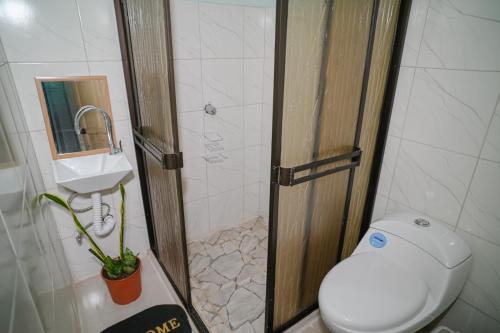 a small bathroom with a toilet and a sink at Cabinas Los Colibris in Pocosol
