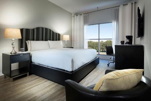 a bedroom with a large bed and a chair at Meliá Orlando Celebration in Orlando