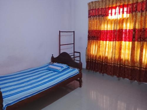 a bedroom with a bed and a colorful curtain at TRAVAL dksr in Anuradhapura