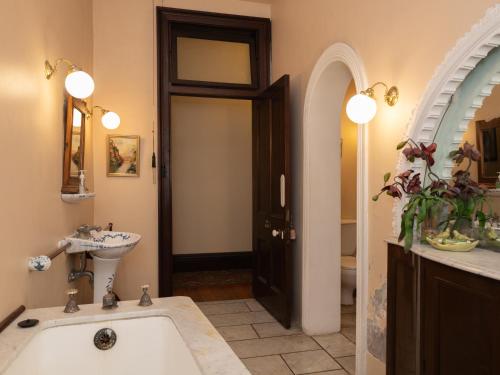 a bathroom with a bath tub and a sink and a mirror at Lochinvar House in Lochinvar