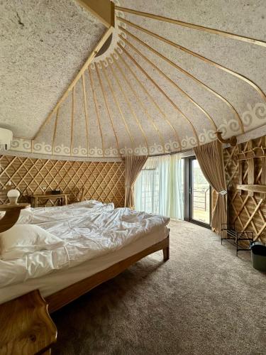 a bedroom with a bed and a large window at Tangnuru eco yurts in Bosteri