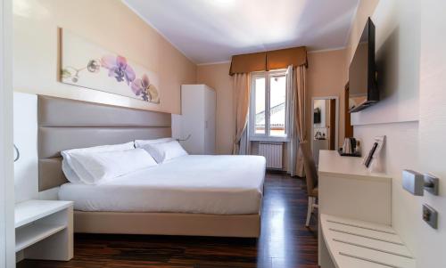 a bedroom with a white bed and a window at Hotel University in Bologna