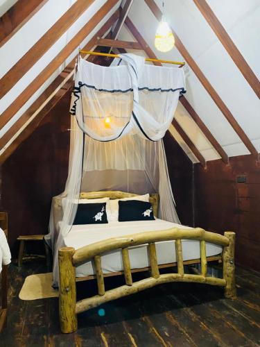 a bedroom with a canopy bed in a attic at Sigiri Veenus Tree House in Sigiriya