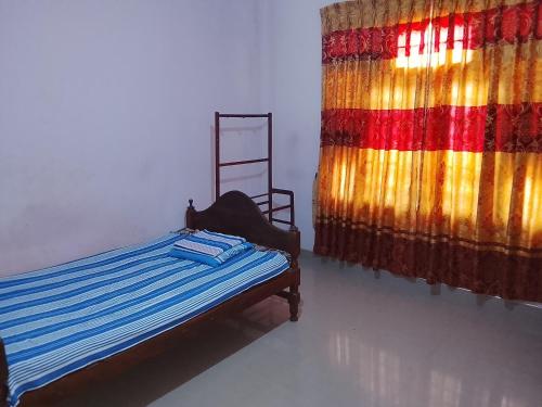 a bedroom with a bed and a colorful curtain at TRAVAL dksr in Anuradhapura