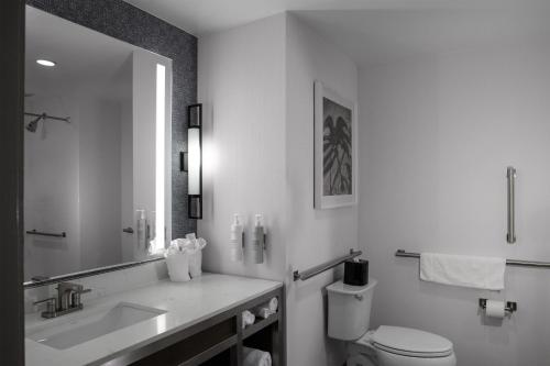 a bathroom with a sink and a toilet and a mirror at Hilton Garden Inn Jackson in Jackson