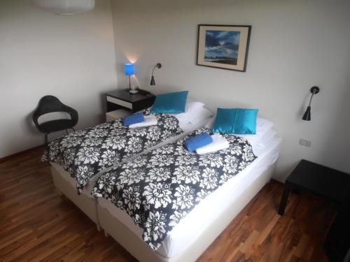 1 dormitorio con 1 cama con almohadas azules en Giljur Guesthouse en Vík