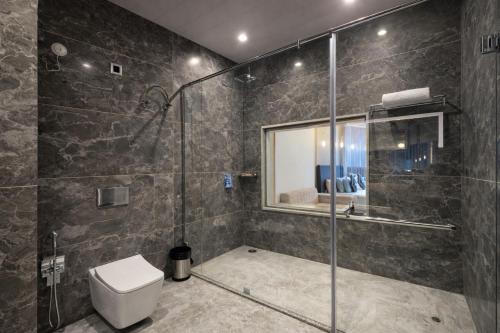a bathroom with a glass shower with a toilet at Kavin - The Chail Resort in Chail