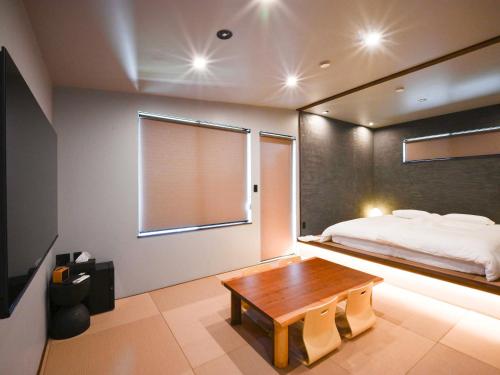 a bedroom with a bed and a wooden table at FOG villa&spa in Kirishima