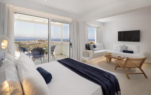 a hotel room with a bed and a living room at Paradisia Suites in Naxos Chora