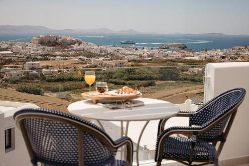 a table with a plate of food and a glass of wine at Paradisia Suites in Naxos Chora