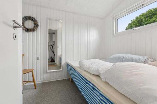 a bedroom with a bed and a window at Nordic Style Summer House For Two in Bogense