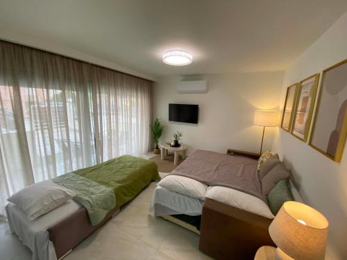 a bedroom with two beds and a large window at Nikol's central suite 2 in Nea Peramos