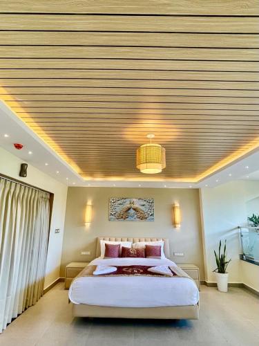 a bedroom with a large bed and a ceiling at Casa Amarilla Hotel in Dona Paula