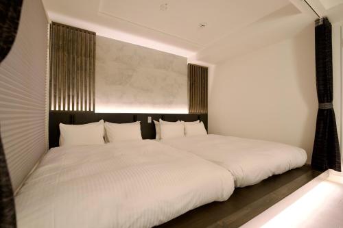 a bedroom with a large white bed with white pillows at Grand Success Kotoni ll in Sapporo