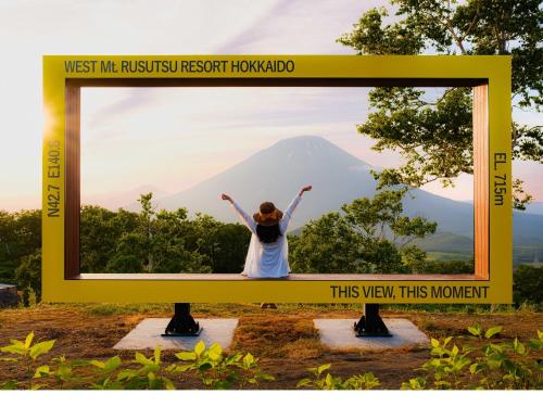 a sign with a picture of a woman in front of a mountain at Rusutsu Resort Hotel & Convention in Rusutsu