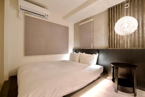 a bedroom with a white bed and a table at Grand Success Kotoni ll in Sapporo
