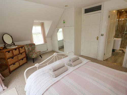 a bedroom with a bed and a dresser and a chair at North Studdock Cottage in Pembroke