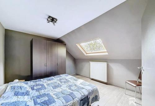 a bedroom with a bed and a skylight at Zur alten schule in Amblève