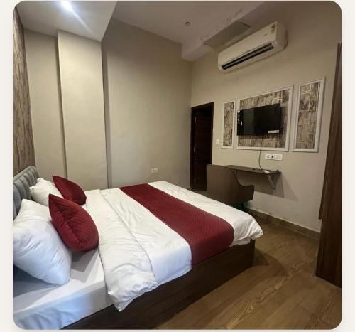 a bedroom with a bed with red and white pillows at YU Turn Celebrations in Greater Noida