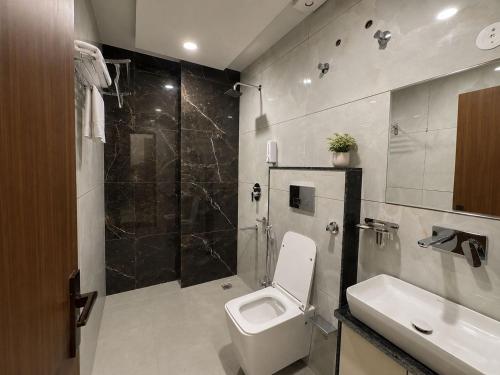 a bathroom with a toilet and a sink and a shower at Hotel RajKailash in Jaipur