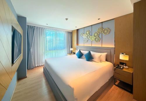 a bedroom with a large bed and a window at Wyndham La Vita Rawai Phuket in Rawai Beach