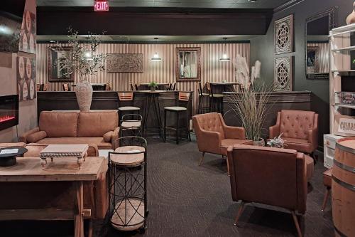a living room with a couch and chairs and a bar at Clarion Inn Grand Junction Airport in Grand Junction