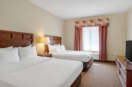 a hotel room with two beds and a television at Quality Suites San Antonio Northeast in San Antonio