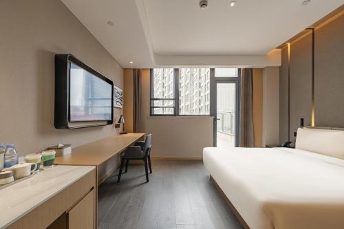 a hotel room with a bed and a television at 上海临港新城万达广场亚朵酒店 in Shanghai