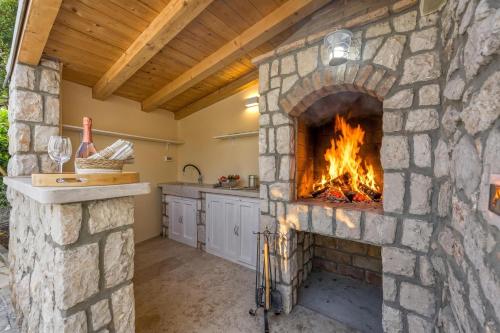 a stone fireplace in the kitchen of a house at Island Villa Alba with Terrace & Grill - Happy Rentals in Mali Lošinj