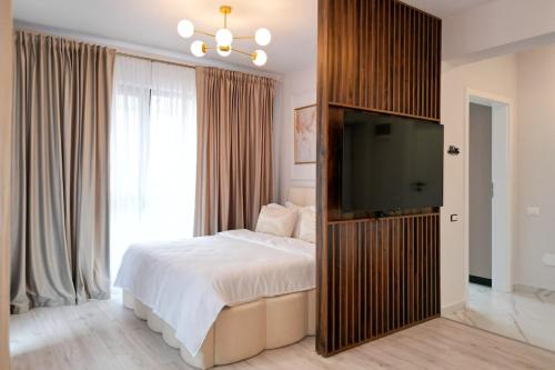 a bedroom with a bed and a flat screen tv at Luxury Studio Chiajna in Roşu