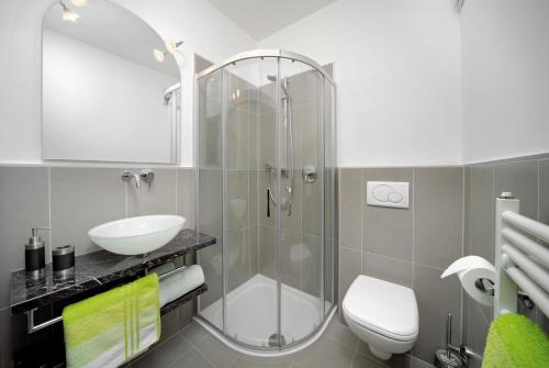 a bathroom with a shower and a toilet and a sink at Hotel Garni Vigilhof in Lana