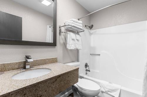 a bathroom with a sink and a toilet and a mirror at Quality Inn Oskaloosa in Oskaloosa