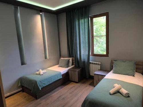 a room with two beds and a window at Fortuna Gabala Boutique Hotel & Restaurant in Gabala
