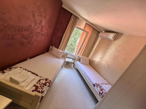 a small room with two beds and a window at Hotel Trakia in Plovdiv