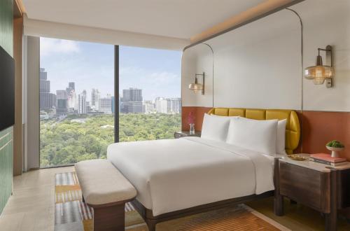 a bedroom with a large white bed and a large window at Andaz One Bangkok, by Hyatt in Bangkok