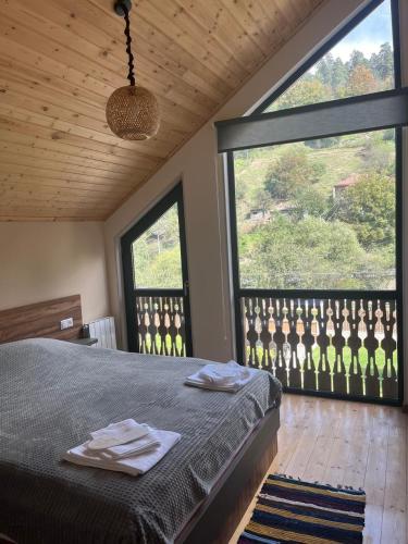 a bedroom with a bed and two large windows at Two Dilijan big pool in Dilijan