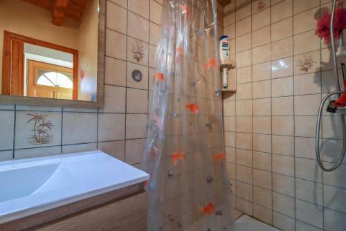 a bathroom with a shower with orange fish on the shower curtain at Au cabanous in Boutx