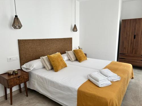 a bedroom with a large white bed with yellow pillows at Las Casillas de Laujar in Laujar de Andarax